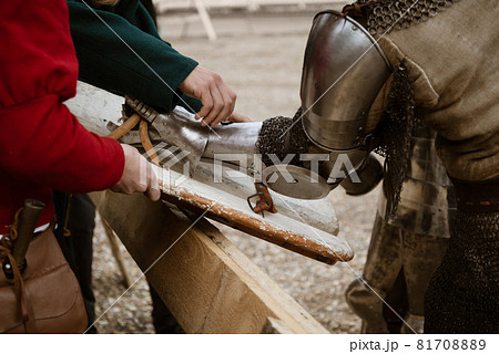 Squires help the knight to attach the shield to the armor on his arm before the battle. Reconstruction of medieval traditions 81708889