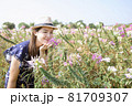 Beautiful woman relaxing in a beautiful flower field watching the sunset. 81709307