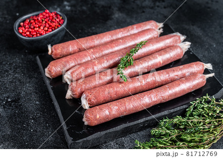 Fresh Raw butchers sausages in skins with thyme on marble board. Black background. Top view Fresh Raw butchers sausages in skins with thyme on marble board. Black background. Top view 81712769