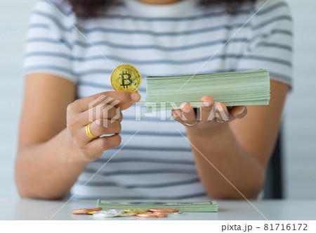 Hands holding crypto coin and stack of banknotes money and the comparison gesture. Concept of investment in digital assets and old-school treasure Hands holding crypto coin and stack of banknotes money and the comparison gesture. Concept of investment in digital assets and old-school treasure 81716172