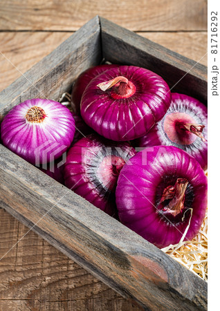 Flat red sweet onion in wooden box. Wooden background. Top View Flat red sweet onion in wooden box. Wooden background. Top View 81716292
