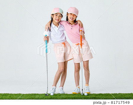 Portrait isolated studio shot of two Asian little professional girl golfers in sport fashion clothing uniform stand smile hug each other shoulder hold putter grip on green in front white background Portrait isolated studio shot of two Asian little professional girl golfers in sport fashion clothing uniform stand smile hug each other shoulder hold putter grip on green in front white background 81717549