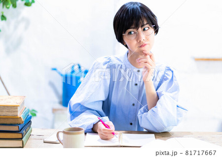 自宅勉強中に悩む眼鏡の若い女性 自宅勉強中に悩む眼鏡の若い女性 81717667