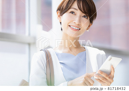 外出先でスマホのアプリを操作する女性 外出先でスマホのアプリを操作する女性 81718432
