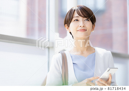 外出先でスマホのアプリを操作する女性 81718434