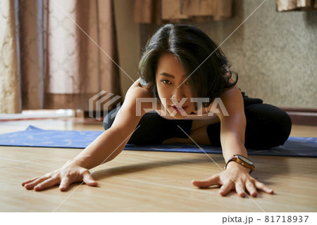 Woman Practicing Crossed Leg Forward Stretch Woman Practicing Crossed Leg Forward Stretch 81718937