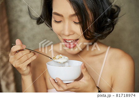 Young Woman Eating Granola Young Woman Eating Granola 81718974