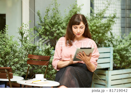 Young Woman Reading News Article Young Woman Reading News Article 81719042