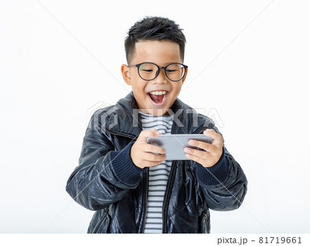 Cut out portrait of smart Asian boy wearing glasses and casual black jacket exciting and happily laugh as enjoy playing attractive funny game and interesting info on favorite mobile phone Cut out portrait of smart Asian boy wearing glasses and casual black jacket exciting and happily laugh as enjoy playing attractive funny game and interesting info on favorite mobile phone 81719661