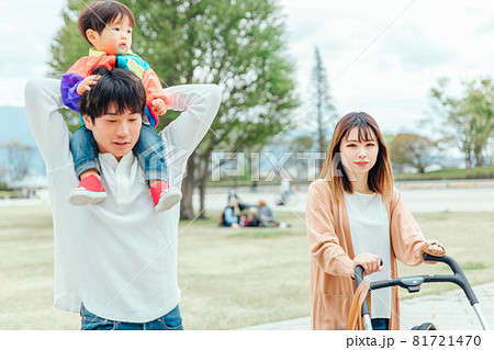 赤ちゃんを肩車して歩くパパとママの写真素材