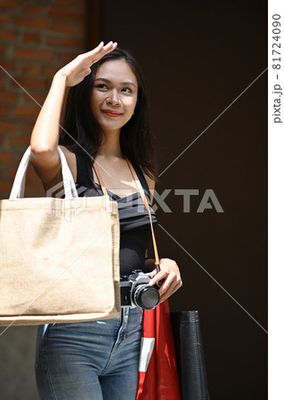Young pretty woman walk on the street with shopping bags. 81724090