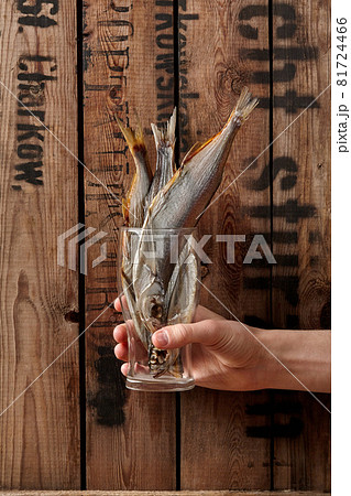 Male hand holding glass with air-dried salted sabrefish 81724466