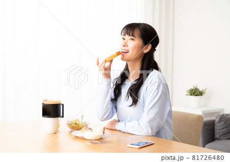 朝食でパンを食べる女性 81726480