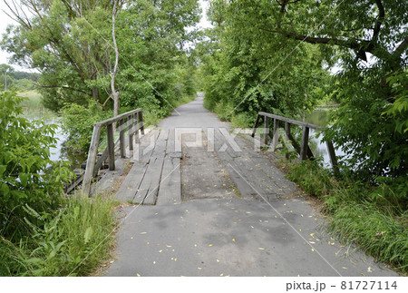 Beautifully standing old wooden bridge over river in colored background Beautifully standing old wooden bridge over river in colored background 81727114