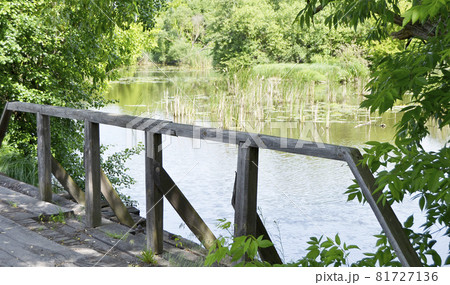 Beautifully standing old wooden bridge over river in colored background Beautifully standing old wooden bridge over river in colored background 81727136