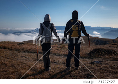 woman and man in nature wearing hiking backpacks and sticks. woman and man in nature wearing hiking backpacks and sticks. 81727427