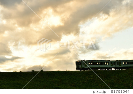 北杜市小淵沢町、夕焼雲の下を行く小海線列車。ヘッドライト 81731044