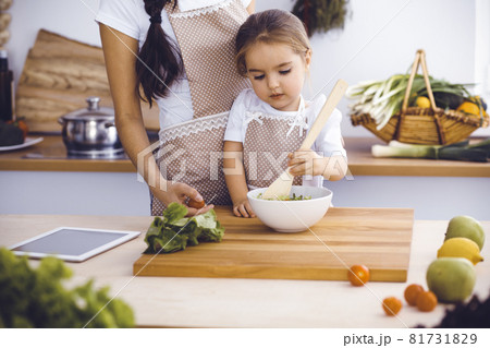 Happy woman and her daughter making healthy vegan salad and snacks for family feasting. Christmas, New year, Thanksgiving, Anniversary, Mothers Day. Healthy meal cooking concept 81731829