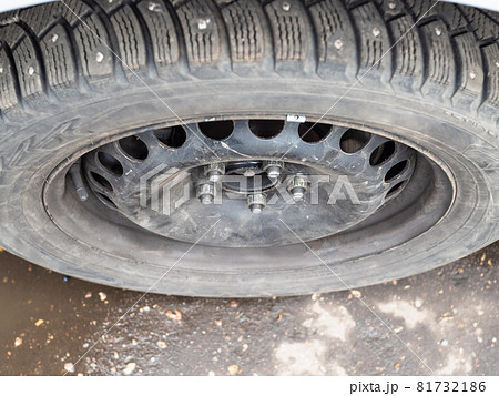 top view of attached used studded winter tire on car during for seasonal replacement of wheels 81732186