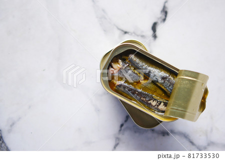 open tin of sardines on white tiles background. open tin of sardines on white tiles background. 81733530