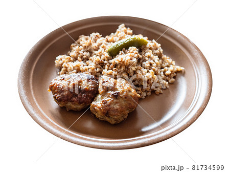 portion of fried Kotleta (breaded minced beef steaks) , side dish from boiled buckwheat porridge on brown plate cut out on white background portion of fried Kotleta (breaded minced beef steaks) , side dish from boiled buckwheat porridge on brown plate cut out on white background 81734599