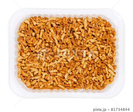 Vegan minced meat, in a clear plastic tray. Substitute and alternative for ground meat, based on seasoned pea protein, passed through a spiral screw mincer. Close-up from above over white, food photo. Vegan minced meat, in a clear plastic tray. Substitute and alternative for ground meat, based on seasoned pea protein, passed through a spiral screw mincer. Close-up from above over white, food photo. 81734844