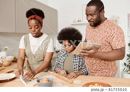 Young African family of three cooking homemade pastry Young African family of three cooking homemade pastry 81735010