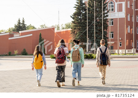Group of schoolkids with backpacks going to school in the morning 81735124