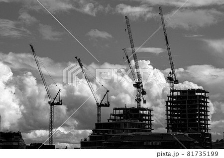 Silhouettes of cranes and buildings under construction in downtown London set against a dramatic cloudy sky. Silhouettes of cranes and buildings under construction in downtown London set against a dramatic cloudy sky. 81735199