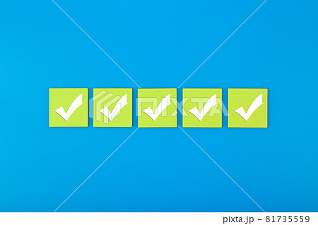 Five checkmarks on bright green tablets in the middle of blue background  81735559