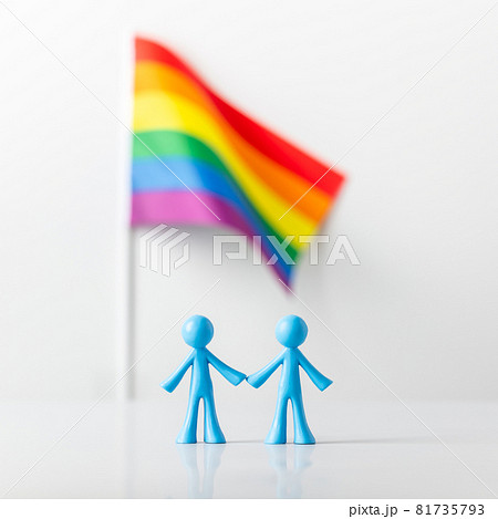 Plastic figures of gay couple and LGBT rainbow flag on light gray background Plastic figures of gay couple and LGBT rainbow flag on light gray background 81735793