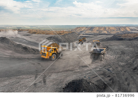 Large quarry dump truck. Big yellow mining truck at work site. Loading coal into body truck. Production useful minerals. Mining truck mining machinery to transport coal from open-pit production 81736996