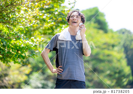 外で運動後に汗を拭う男性 81738205
