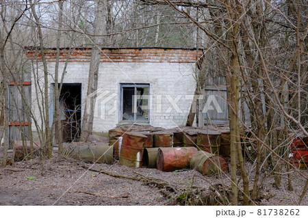 Rusty metal barrels near an abandoned brick building. Building in the Chernobyl exclusion zone. Rusty metal barrels near an abandoned brick building. Building in the Chernobyl exclusion zone. 81738262