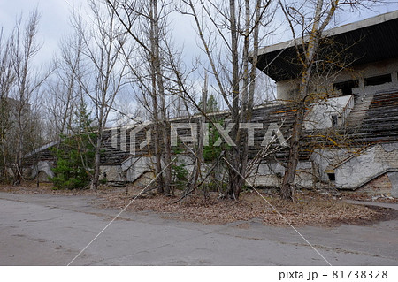 An abandoned football stadium in Pripyat. Overgrown with trees ruins of the stadium. An abandoned football stadium in Pripyat. Overgrown with trees ruins of the stadium. 81738328