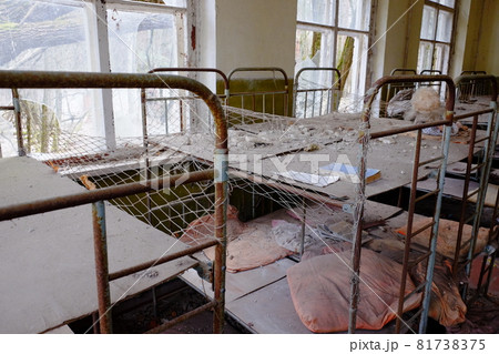 Old children's beds in an abandoned kindergarten. The interior of a room in one of the buildings in the Chernobyl radioactive exclusion zone. Old children's beds in an abandoned kindergarten. The interior of a room in one of the buildings in the Chernobyl radioactive exclusion zone. 81738375