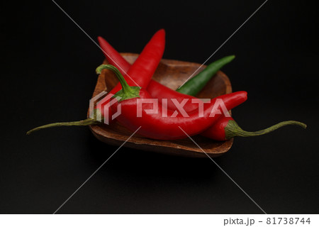 Chili peppers on wooden over a black background Chili peppers on wooden over a black background 81738744