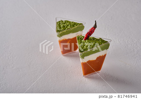 Verrine mousse from baked pepper with creamy gorgonzola and pesto in transparent buffet shape cup 81746941