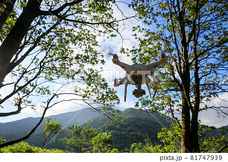 White drone with camera flying in summer mountains White drone with camera flying in summer mountains 81747939