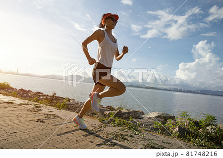 Fitness woman running on sunny tropical seaside Fitness woman running on sunny tropical seaside 81748216
