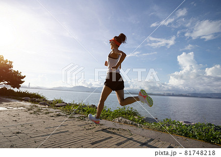 Fitness woman running on sunny tropical seaside Fitness woman running on sunny tropical seaside 81748218