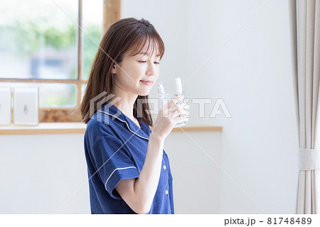 パジャマ姿でミネラルウォーターを飲む若い女性 パジャマ姿でミネラルウォーターを飲む若い女性 81748489