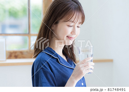 パジャマ姿でミネラルウォーターを飲む若い女性 パジャマ姿でミネラルウォーターを飲む若い女性 81748491