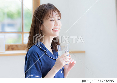 パジャマ姿でミネラルウォーターを飲む若い女性 パジャマ姿でミネラルウォーターを飲む若い女性 81748495