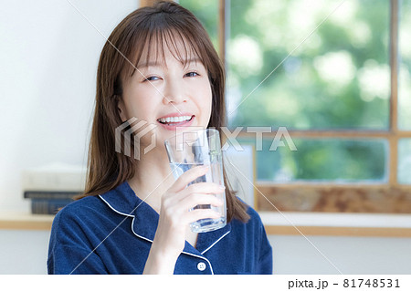 パジャマ姿でミネラルウォーターを飲む若い女性 パジャマ姿でミネラルウォーターを飲む若い女性 81748531