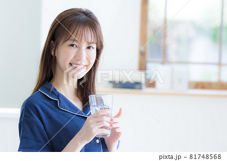 パジャマ姿でミネラルウォーターを飲む若い女性 パジャマ姿でミネラルウォーターを飲む若い女性 81748568