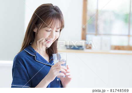 パジャマ姿でミネラルウォーターを飲む若い女性 パジャマ姿でミネラルウォーターを飲む若い女性 81748569