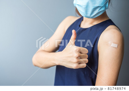 Happy woman showing thumb with bandage after receiving covid 19 vaccine. Vaccination, herd immunity, side effect, efficiency, vaccine passport and Coronavirus pandemic Happy woman showing thumb with bandage after receiving covid 19 vaccine. Vaccination, herd immunity, side effect, efficiency, vaccine passport and Coronavirus pandemic 81748974