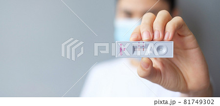 woman holding Rapid Antigen Test kit with Positive result during swab COVID-19 testing. Coronavirus Self nasal or Home test, Lockdown and Home Isolation concept 81749302