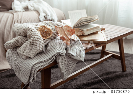 Autumn composition with a sweater and a book in the interior of the room. 81750379